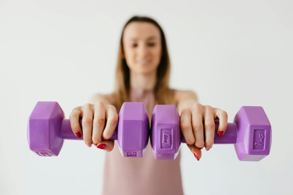 sweat equity biceps bliss hustle fitness Defocused content young female doing bicep exercise with dumbbells during functional training in light studio