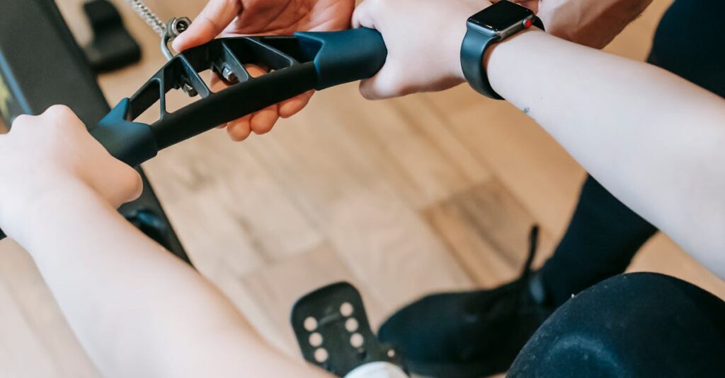Close-up of a personal trainer guiding a client on a rowing machine during a workout session.